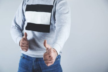 Gri arka planda bir iş adamı başparmağını kaldırdı.