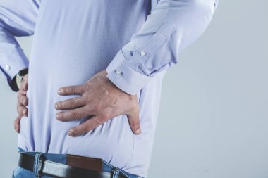 Adam el üstünde sırt ağrısı, gri arka planda