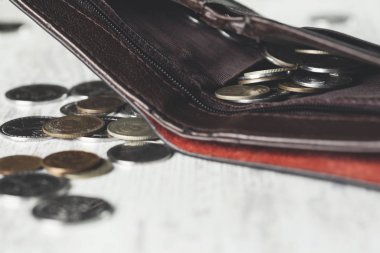 Cüzdandaki bozuk paralar ahşap masada.