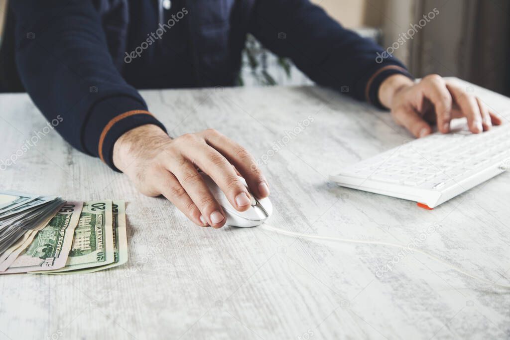 man hand money with computer on desk