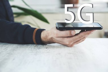 Ekranda 5G mesajı olan bir adam cep telefonu