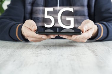 Ekranda 5G mesajı olan bir adam cep telefonu