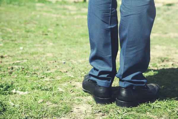 man feet with shoes on green grass