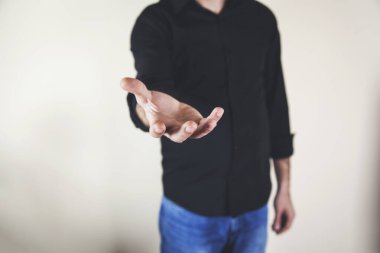 Genç iş adamı sarı arka planda avuç içi boş