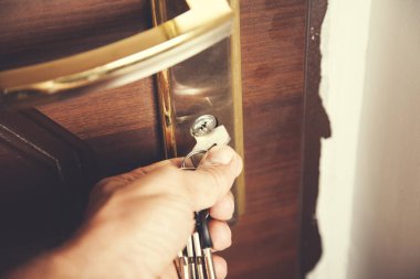 Genç adam kapının üzerinde el anahtarı var.