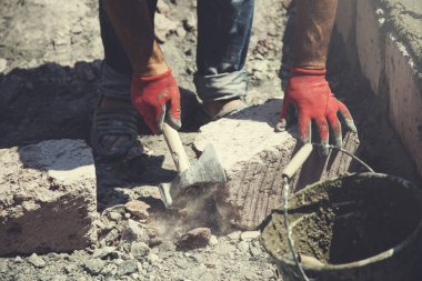 Adam duvar örüyor.