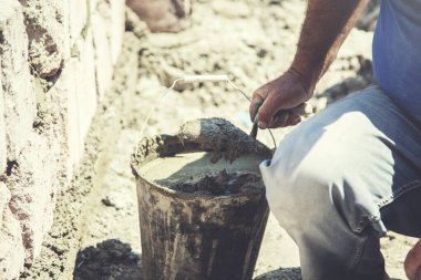 Adam duvar örüyor.