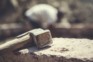 İnşaat alanındaki taşın üzerinde balta var.