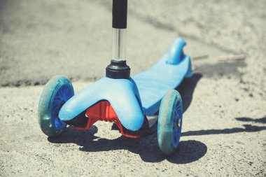 Mavi scooter caddede yerde.