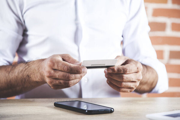 man hand phone with credit card on desk