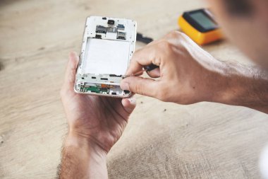 İşçi eli kırık telefon masanın üstünde.