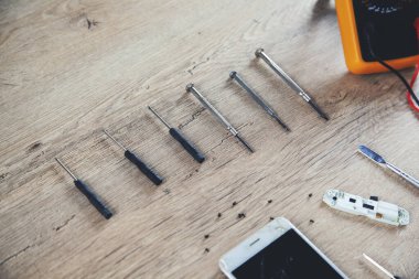 Tahta masanın üzerinde testçi olan telefon.