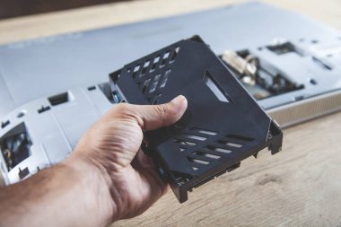 işçi adam masadaki bilgisayarı tamir ediyor.