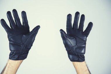 Gri arka planda siyah eldivenli adam