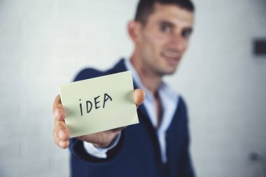 Gri arkaplandaki kağıt üzerinde insan eli fikri metni