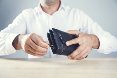 Genç adam el cüzdanı masanın üstünde.