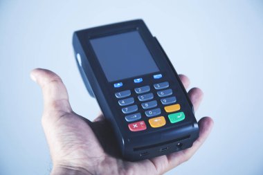 Gri arkaplan üzerinde adam eli ödeme terminali