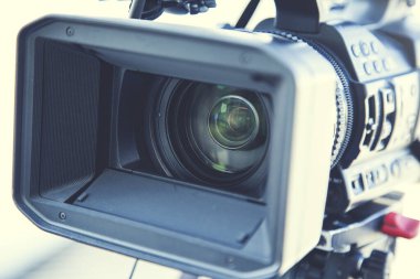 Adam sokakta elinde video kamera tutuyor.