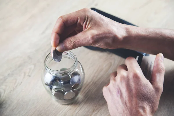 Mann Reicht Glas Mit Münzen Auf Dem Schreibtisch — Stockfoto