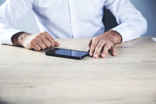 young business man hand smart phone on desk