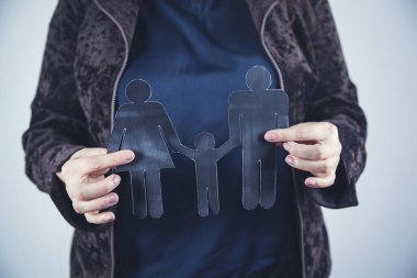 Kadın aile tabelasını kağıt için tutuyor. 