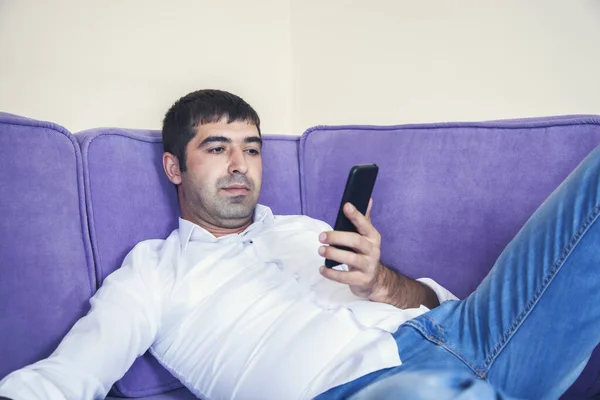 man hand phone sitting on the sofa