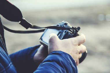 Adam doğada fotoğraf makinesi tutuyor.