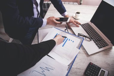 Ekip ofis masasında belge üzerinde çalışıyor.