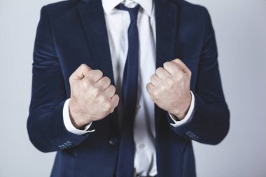 Gri duvardaki arka planda kızgın adam yumrukları