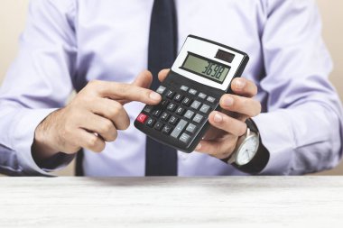 adam el hesap makinesi masa arkasında