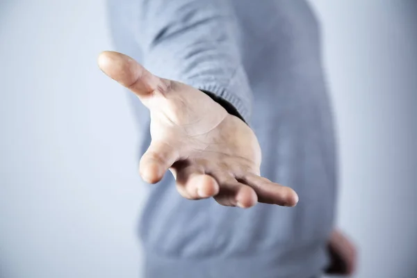 Mann Mit Leerer Hand Auf Grauem Wandhintergrund — Stockfoto