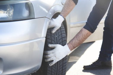 Servis merkezinde araba lastiği olan genç bir tamirci.