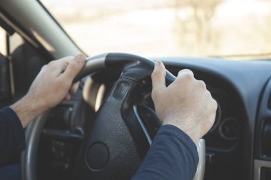 Genç ve neşeli adam yeni arabasını kullanıyor.