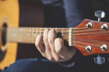 Genç adam doğada güzel müzik çalar.