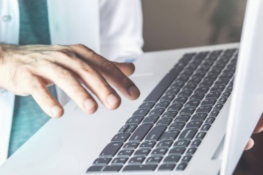 Genç adam masadaki bilgisayar klavyesinde