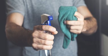 Genç temizlikçi, evi temizlemek için bez tutuyor.