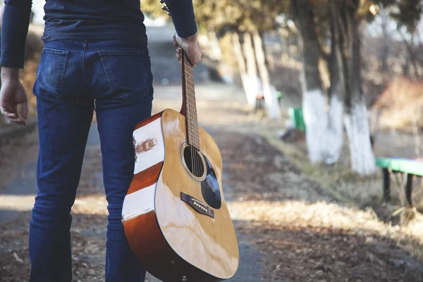 Genç adam doğada güzel müzik çalar.