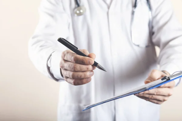 Erkek doktor hastanedeki panoya notlar yazıyor.