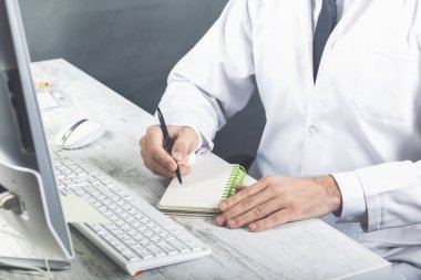 Beyaz elbiseli genç erkekler beyaz defterde bir şeyler yazıyor, yüzü yok, notlar yazıyor, şiir yazıyor, hikayeler yazıyor, doktor tavsiyeler yazıyor.
