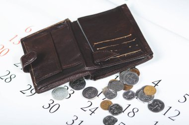 Beyaz takvim arka planında bozuk para olan cüzdan