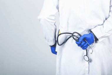 Erkek Doktor gri arka planda duruyor