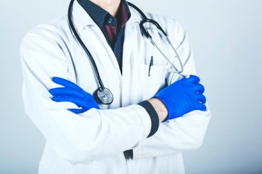 Kolları çapraz ve steteskopla poz veren kendinden emin bir doktor.