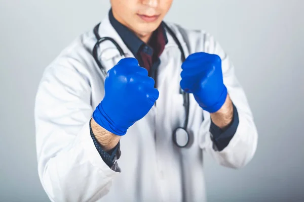 young angry doctor fists on dark background