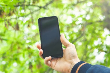 Açık havada cep telefonu kullanan bir adama yaklaş.