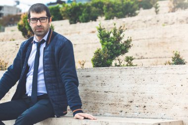 Şehir parkında bir bankta çalışan genç bir işadamı.