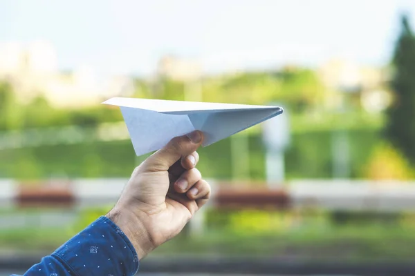 young man holding paper plane in his hand