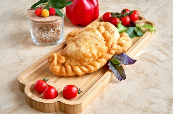 Fried pies on wooden board closeup