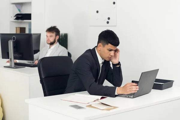 I giovani si siedono ai tavoli e lavorano con i laptop — Foto Stock