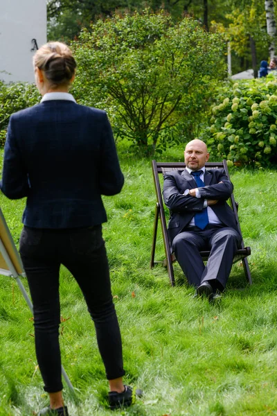 Γυναίκα στέκεται στο γρασίδι και μιλάει με τον άνθρωπο που κάθεται στην καρέκλα σε εξωτερικούς χώρους — Φωτογραφία Αρχείου
