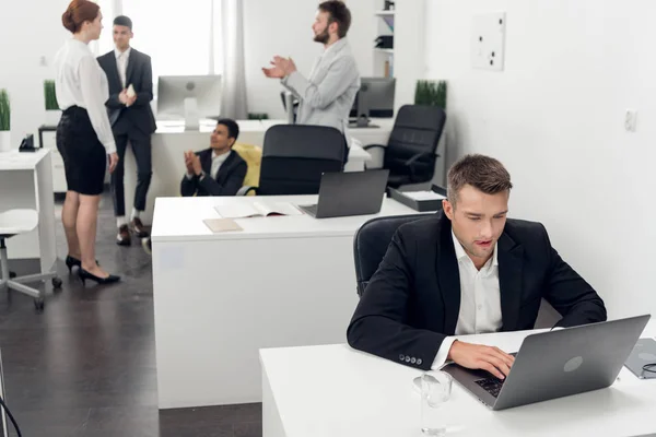 Homens e mulheres têm um tempo de pausa durante o dia de trabalho no escritório, foco no homem jovem que trabalha no laptop — Fotografia de Stock